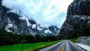 Mountain road between steep cliffs and cloudy sky representing navigating long-term illness leave and workplace risk